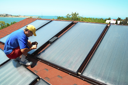 Man adding solar panels to roof to help save energy stop climate change save money.